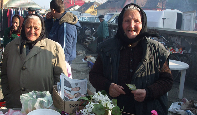 Două doamne se apropie de bătrânica din colțul străzii, care vinde flori! Cu o mână tremurândă, bătrâna apucă 2 buchete de flori, ridică privirea spre cea din fața ei, și îi spune…